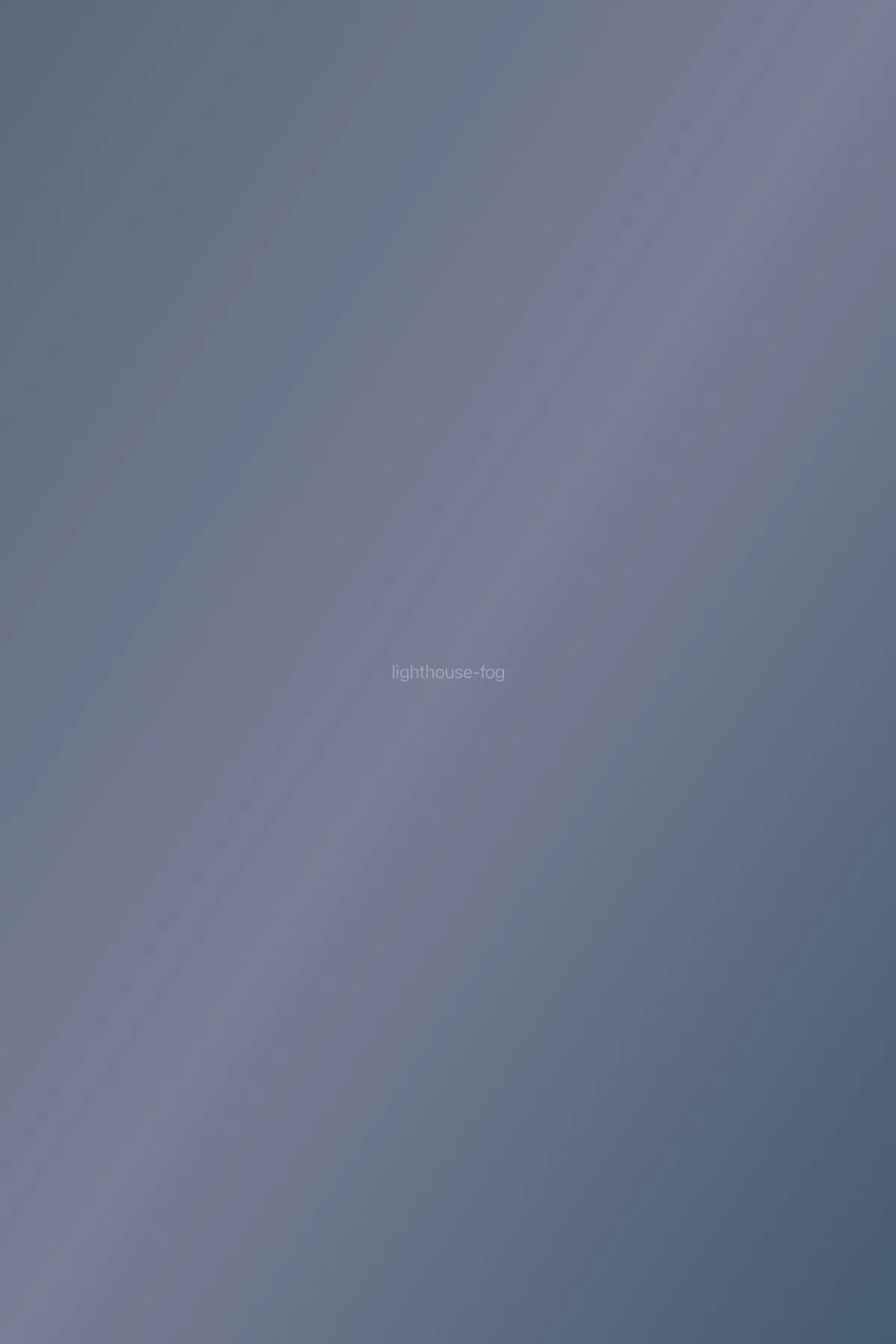 Lighthouse barely visible through thick coastal fog