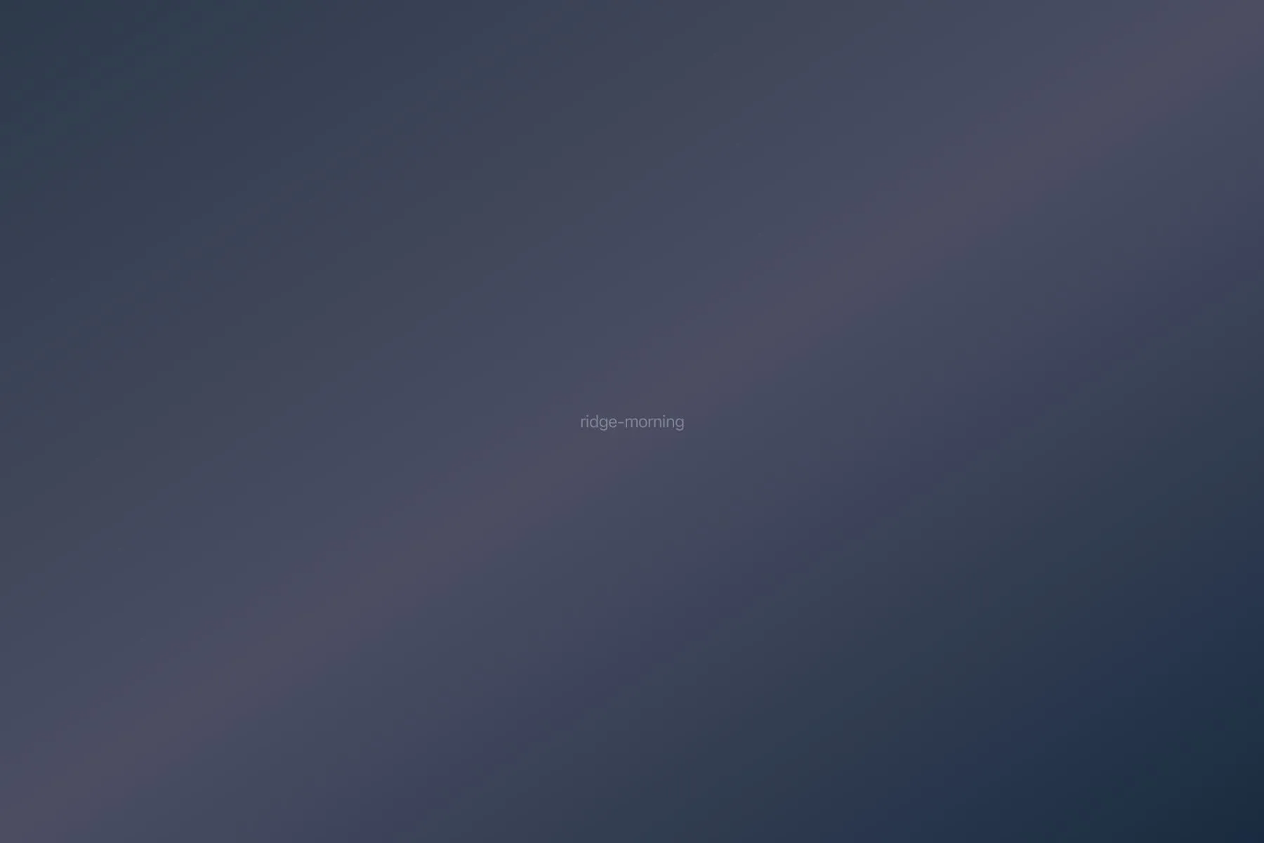 Mountain ridge at dawn with golden light breaking through clouds